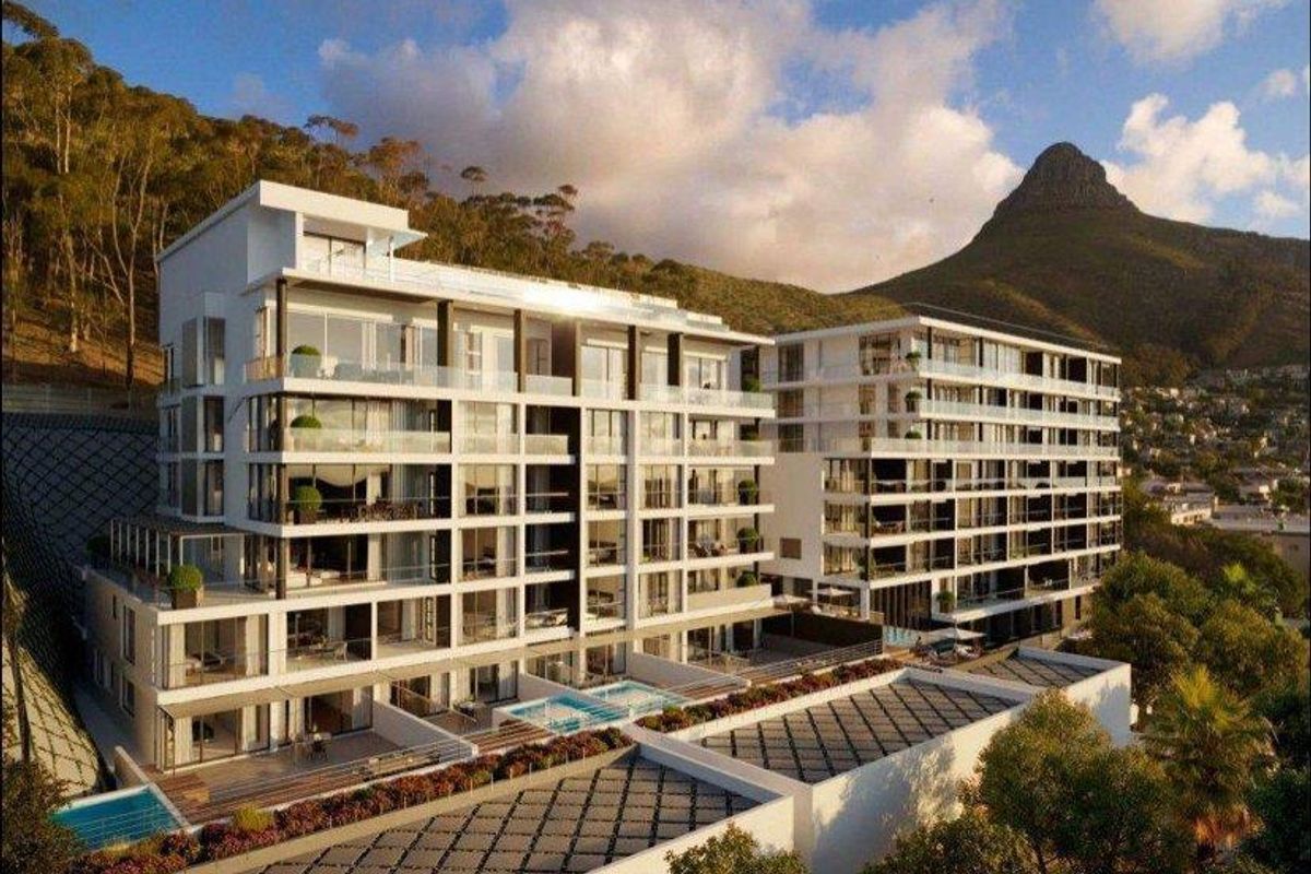 Modern apartment complex featuring tiered balconies, glass balustrades, and private swimming pools, set against a scenic mountain backdrop.