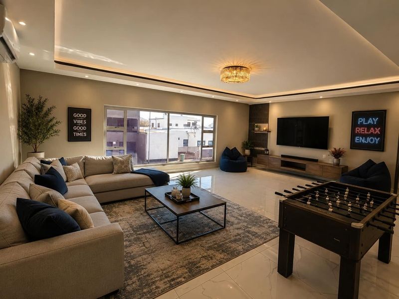 Spacious and modern living room featuring high-end finishes, recessed cove lighting, large windows, and a sleek built-in media console.