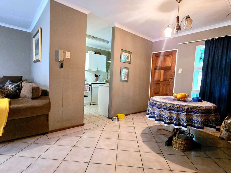 Open plan living and dining area featuring tiled flooring, coved ceilings, and direct access to the kitchen and main entrance.