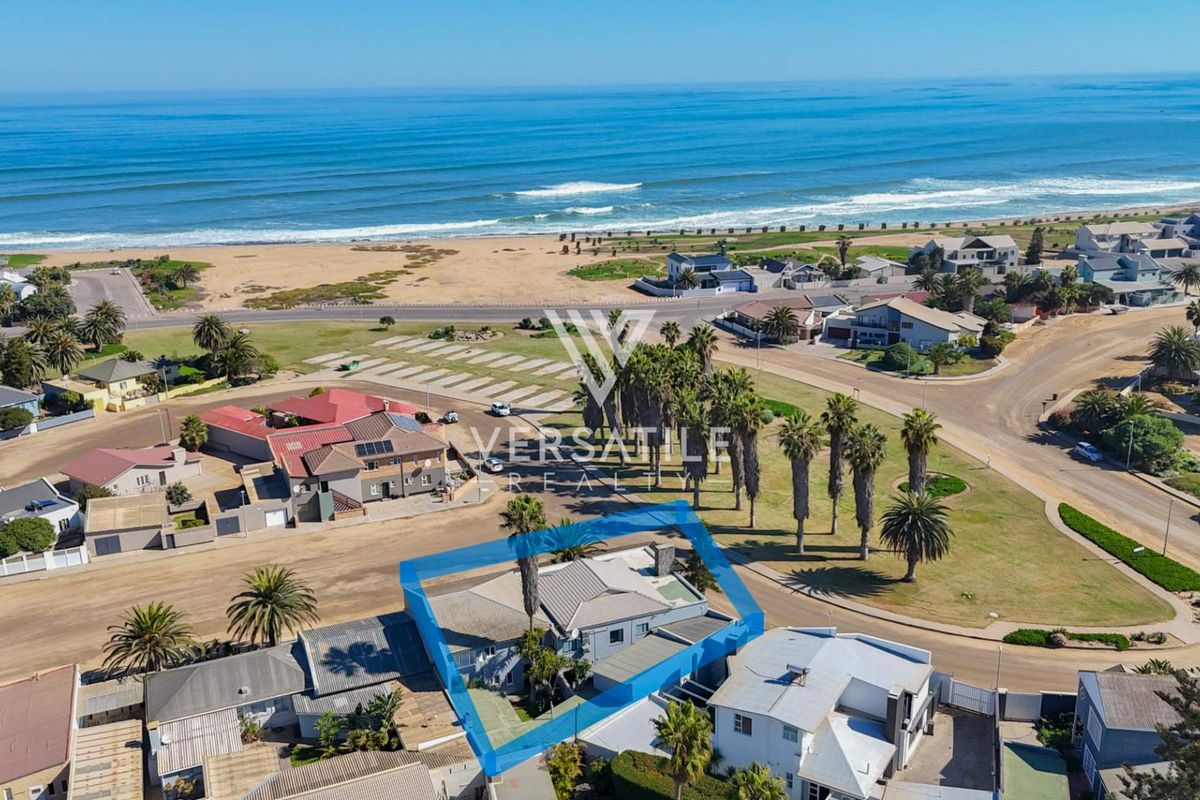 Aerial view of a coastal property highlighting its proximity to the beach and surrounding neighborhood infrastructure.