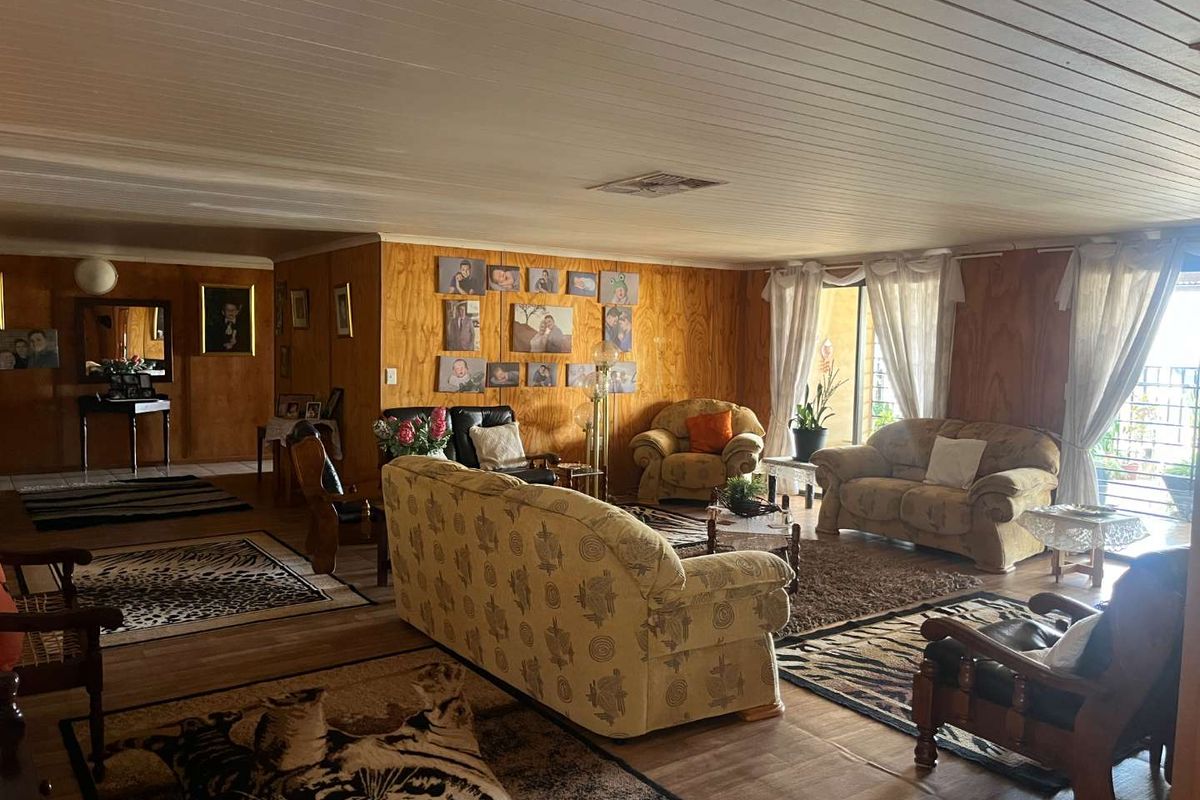 Spacious living area featuring timber wall paneling, a tongue-and-groove ceiling, and large sliding doors providing access to the outdoor patio area.