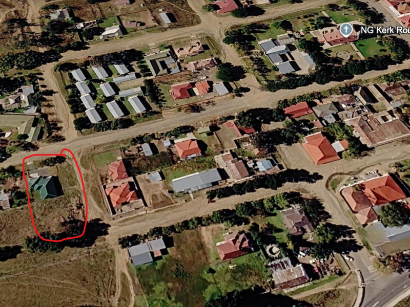 Aerial view of a residential plot in a suburban neighborhood, highlighting the property boundaries and surrounding street layout.