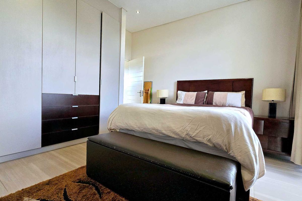 A well-maintained bedroom featuring extensive built-in floor-to-ceiling cabinetry with integrated drawers and modern recessed ceiling lighting.
