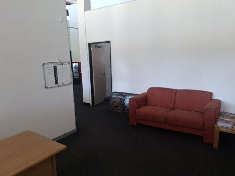 A functional office reception or waiting area featuring carpeted flooring and neutral wall finishes, providing a professional space for clients and staff.