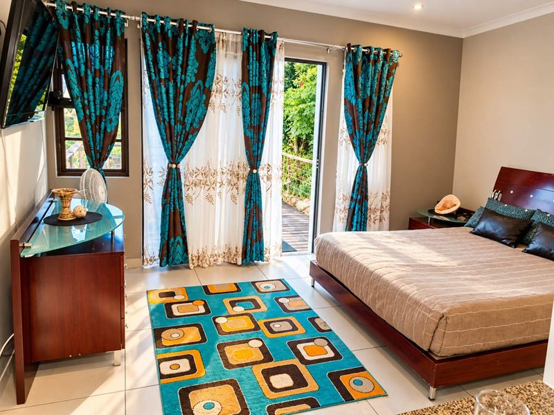 A well-lit bedroom featuring tiled flooring, recessed lighting, and a sliding glass door providing direct access to an outdoor balcony area.