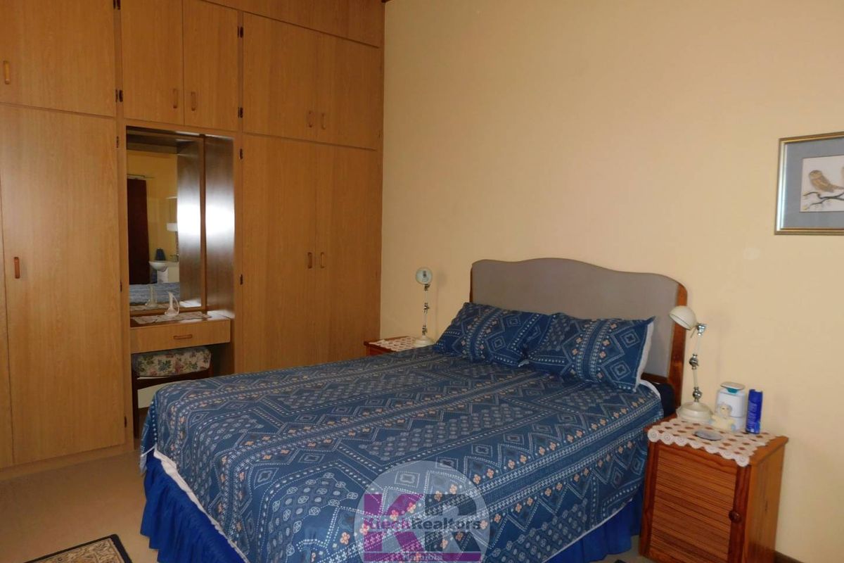A bedroom featuring extensive built-in wooden cabinetry with an integrated vanity mirror.