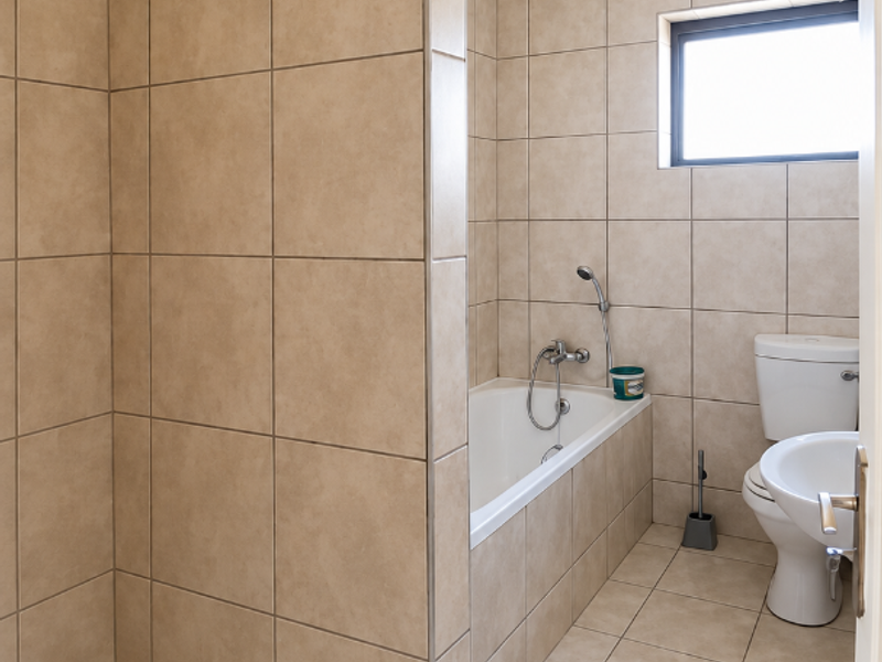 A functional bathroom featuring a walk-in shower, built-in bathtub, toilet, and pedestal basin, finished with neutral ceramic wall and floor tiles.