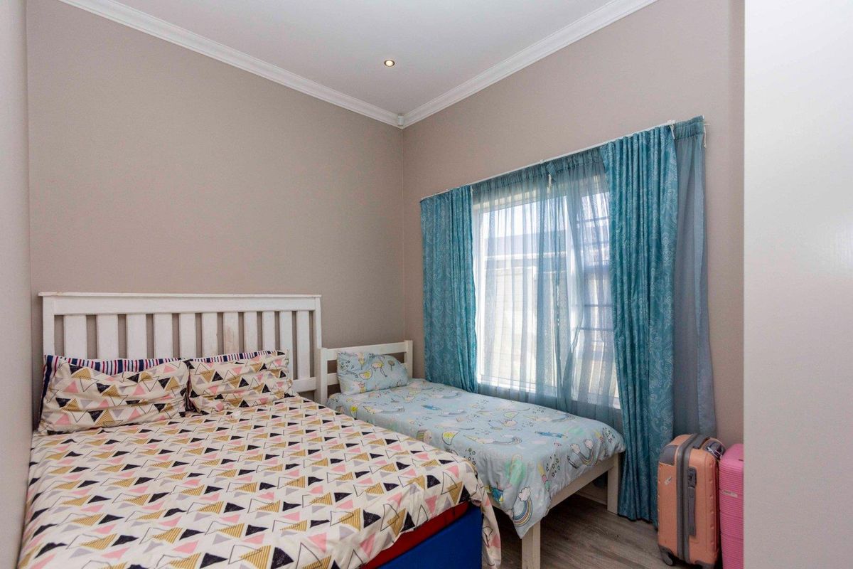 A bedroom featuring neutral wall tones, crown molding, recessed lighting, and a window with fitted curtain tracks.