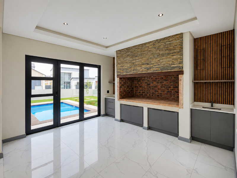 Modern covered patio featuring a built-in brick braai, stone feature wall, timber accents, sleek cabinetry with sink, and bi-fold doors opening to the pool area.