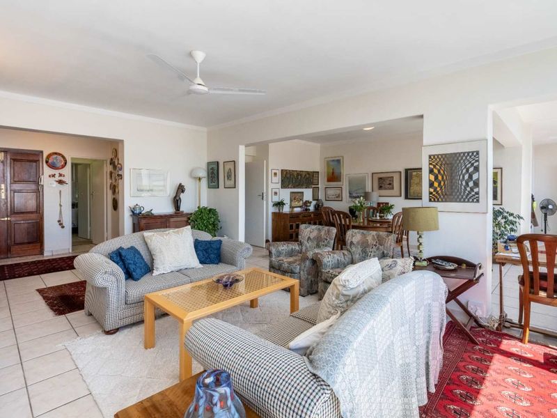 Spacious open-plan living and dining area featuring neutral tiled flooring, coved cornicing, and a ceiling fan, offering a versatile layout for comfortable daily living.