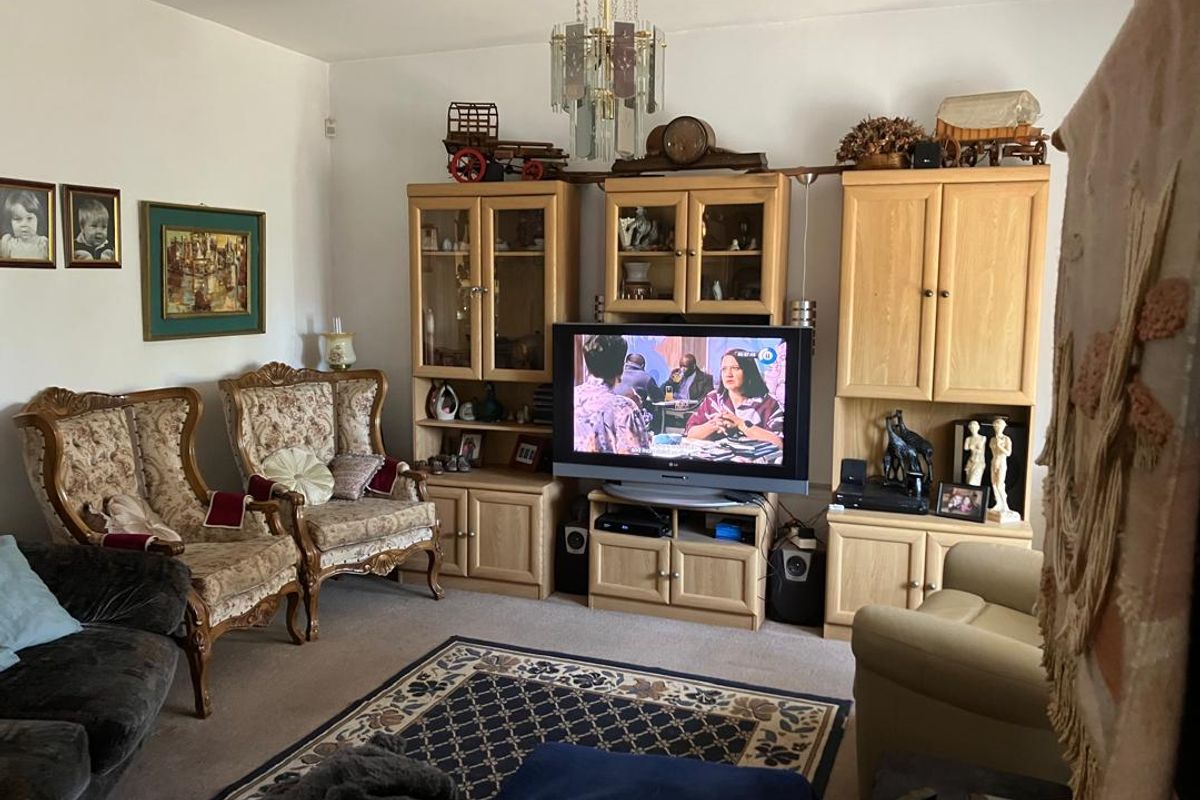 A traditional living room featuring carpeted flooring and a central ceiling light fixture, providing a comfortable and functional space.