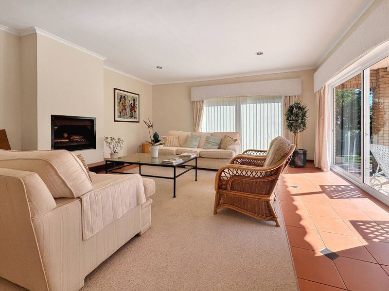 Spacious living room featuring a built-in fireplace, neutral carpeting, and large sliding glass doors that provide ample natural light and access to the outdoors.