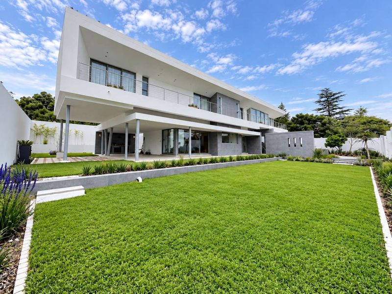 Modern double-story residence featuring a spacious rear garden, covered patio area, and expansive balcony with contemporary architectural finishes.