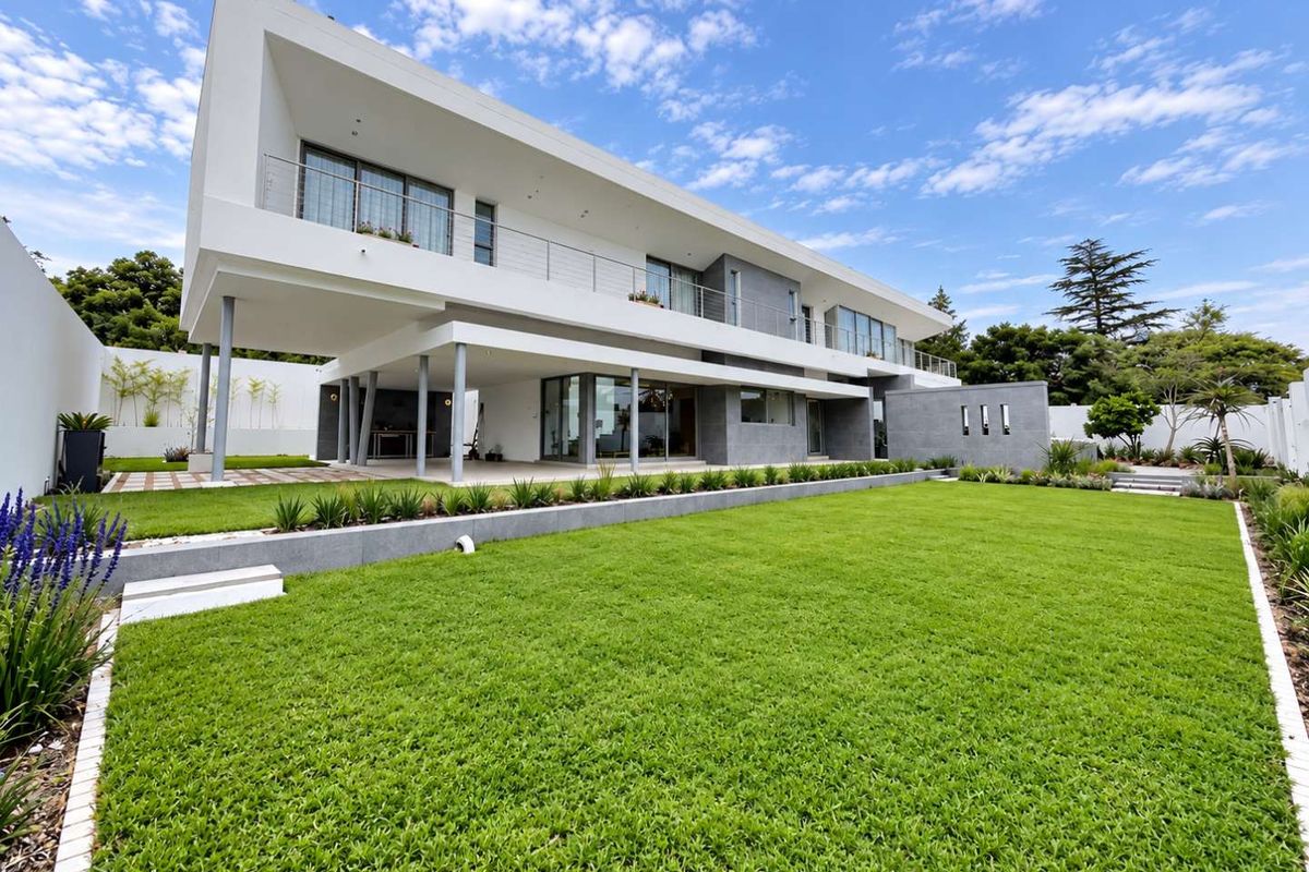 Modern double-story residence featuring a spacious rear garden, covered patio area, and expansive balcony with contemporary architectural finishes.