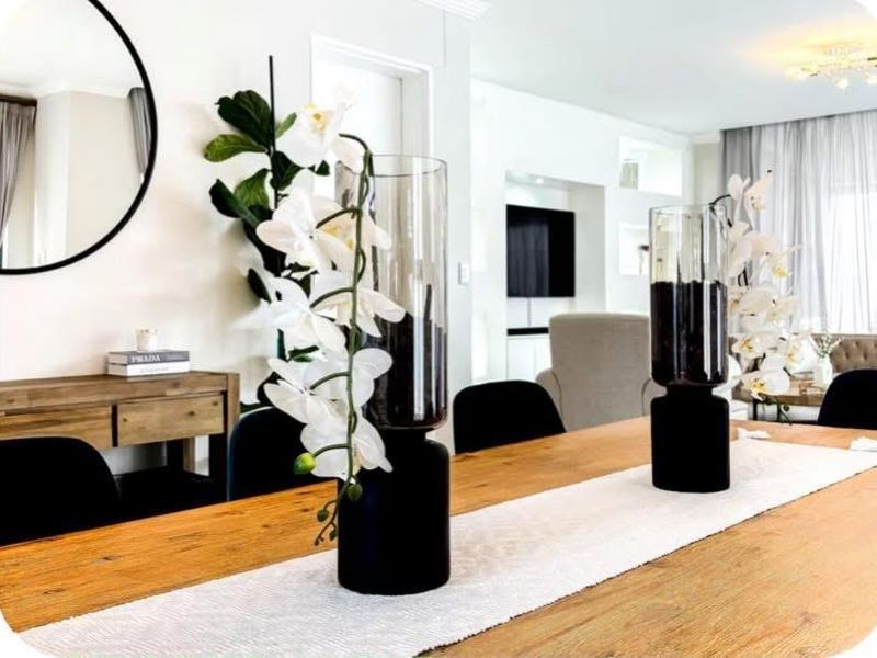 A well-lit dining area featuring modern recessed shelving and elegant cove lighting, creating a bright and inviting space for meals.