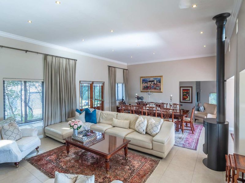Spacious open-plan living and dining area featuring tiled floors, recessed lighting, and a modern freestanding fireplace, creating a comfortable and inviting atmosphere.