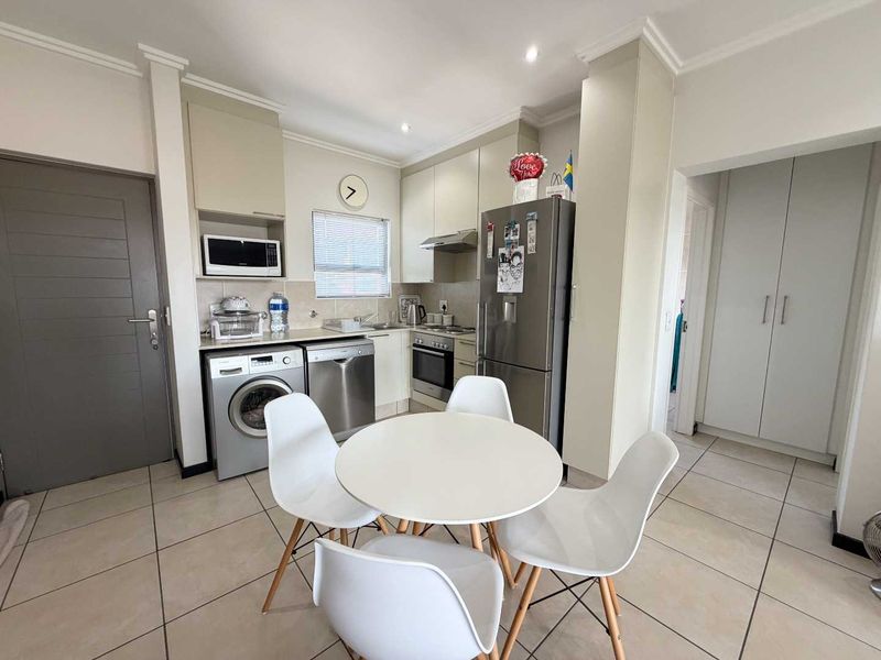 A functional kitchen featuring built-in cabinetry, stainless steel appliances, tiled flooring, and recessed lighting, providing a clean and practical cooking space.