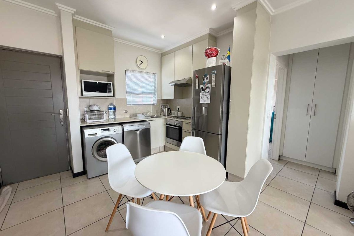 A functional kitchen featuring built-in cabinetry, stainless steel appliances, tiled flooring, and recessed lighting, providing a clean and practical cooking space.