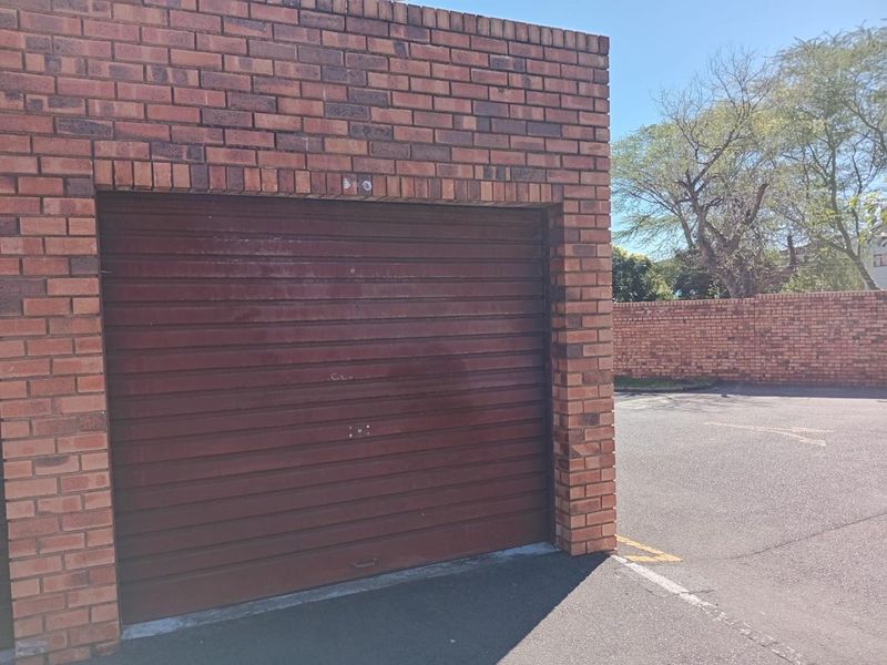 Exterior view of a single brick-constructed garage featuring a standard roll-up door.