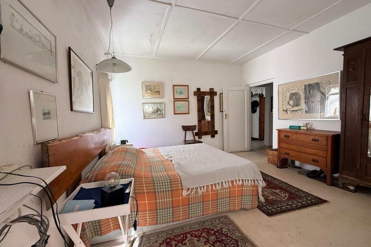 A spacious bedroom featuring a classic panelled ceiling and neutral flooring, offering a blank canvas for potential cosmetic updates and modernization.
