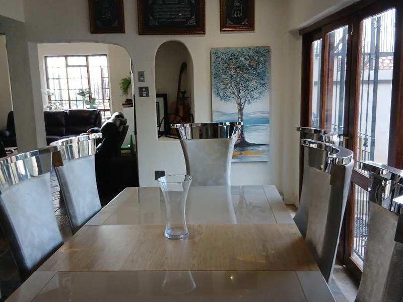 Dining room featuring an arched entryway, recessed lighting, and wooden framed glass doors leading to an outdoor area.