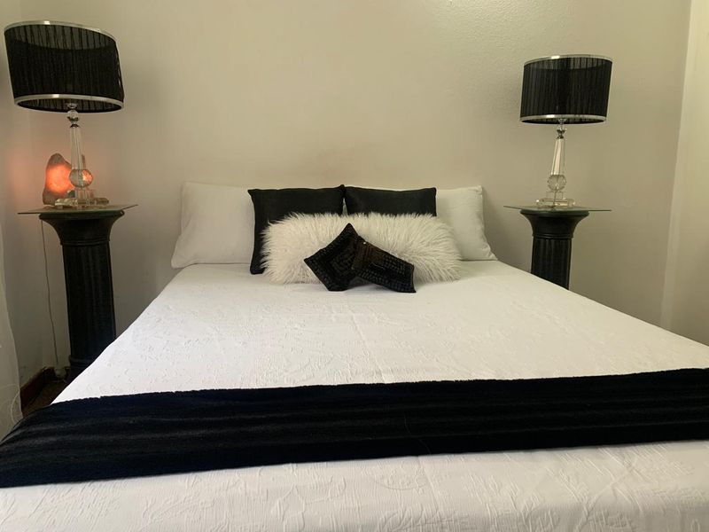 A neutrally painted bedroom featuring a central bed placement, suitable for a retirement village residence.