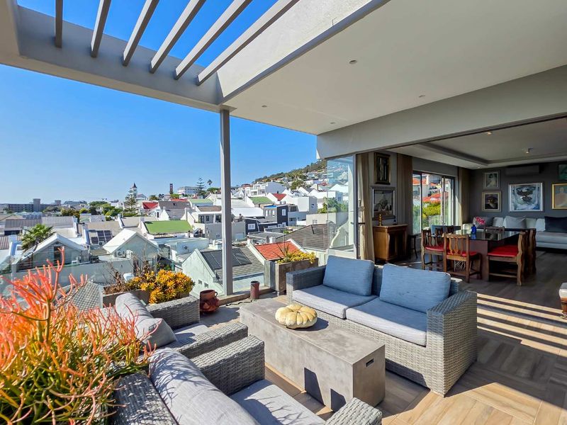 Spacious penthouse balcony featuring a modern pergola, timber decking, and seamless indoor-outdoor flow with panoramic urban views.