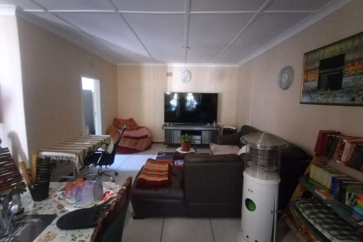 A spacious living room featuring tiled flooring and a coved ceiling, providing a functional and comfortable area for relaxation.