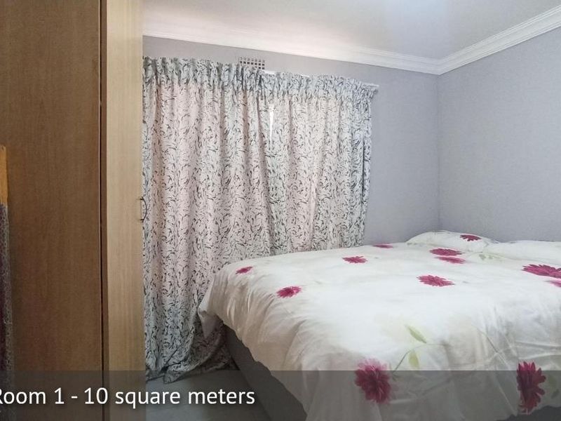 A compact bedroom featuring a built-in wardrobe, neutral wall finishes, and decorative ceiling cornicing.