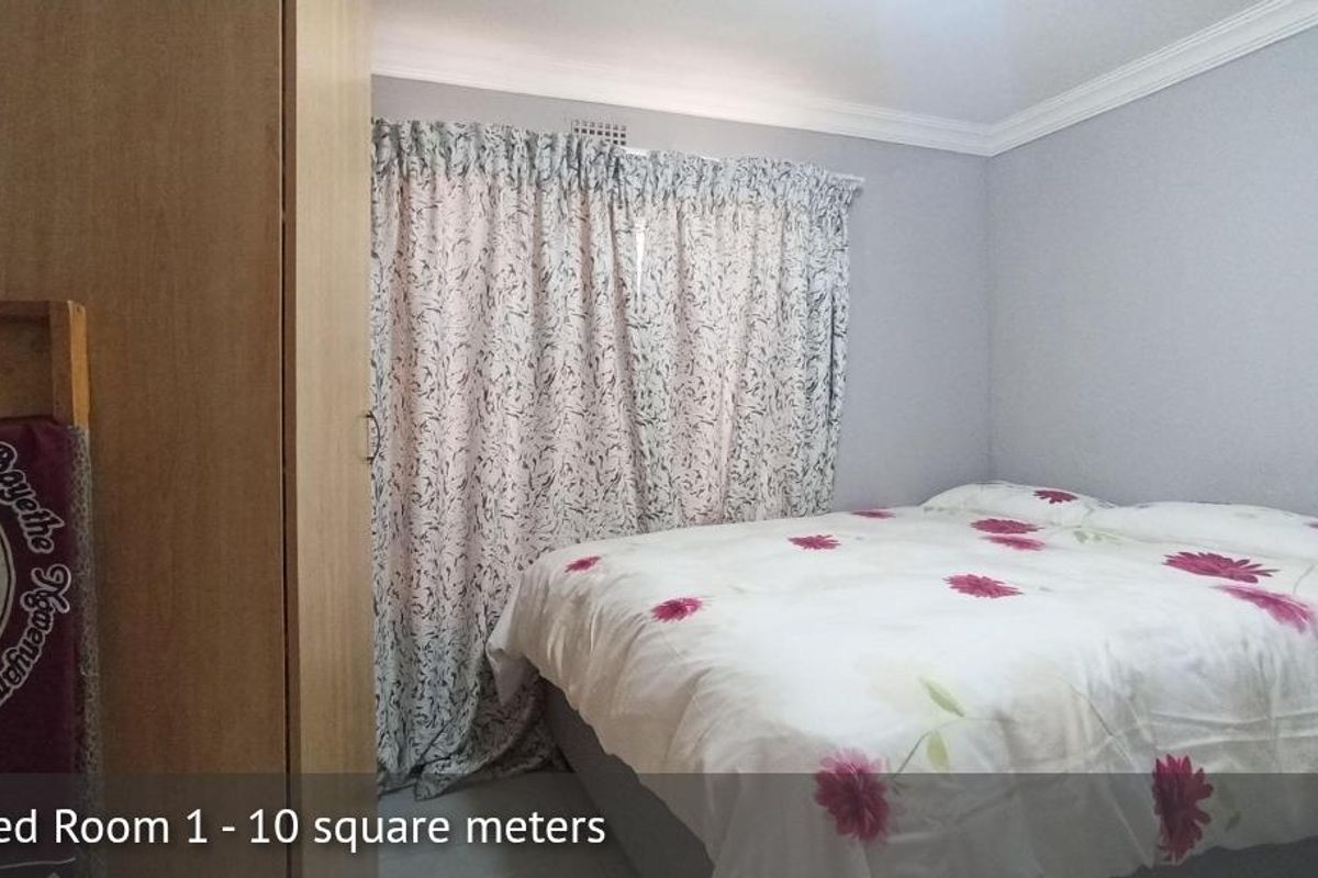 A compact bedroom featuring a built-in wardrobe, neutral wall finishes, and decorative ceiling cornicing.
