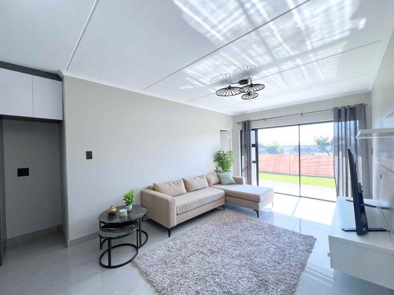 A bright and modern living room featuring large sliding glass doors that provide natural light and access to the outdoor area.