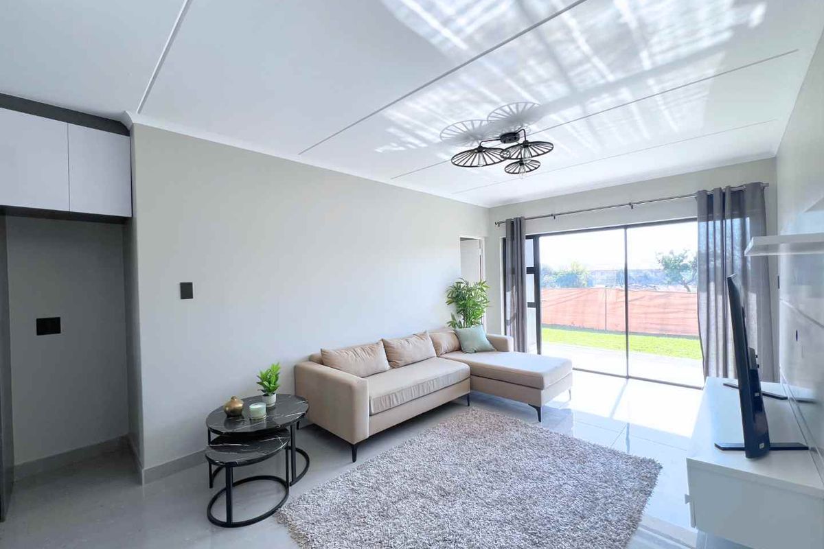 A bright and modern living room featuring large sliding glass doors that provide natural light and access to the outdoor area.