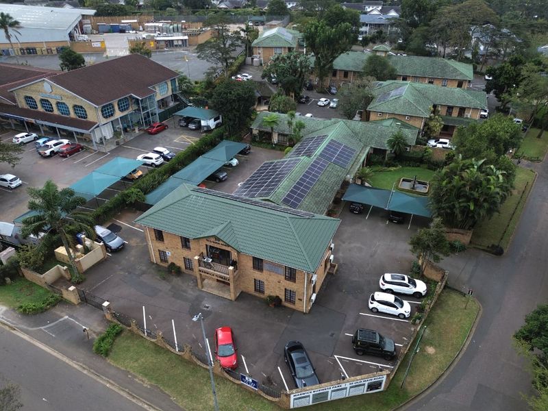 Aerial view of Marwick Terrace office complex featuring brick buildings, tiled roofs with solar panels, and extensive paved parking with covered carports.
