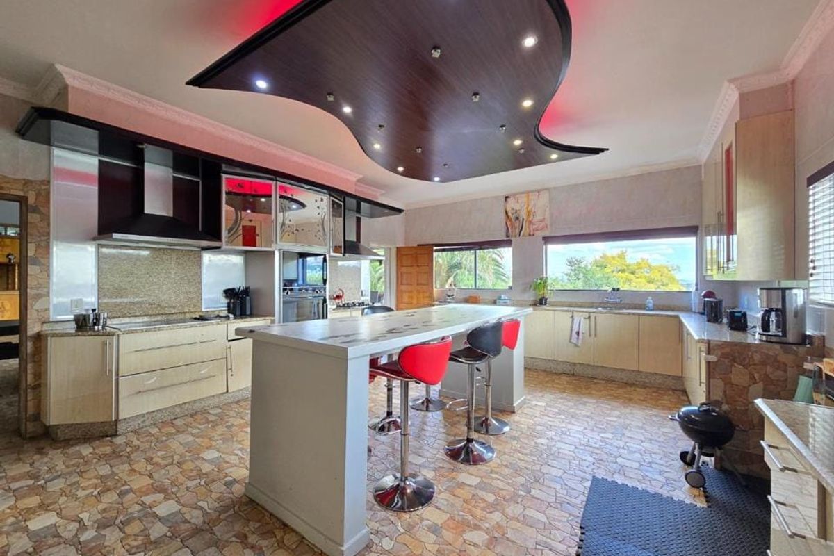 Spacious kitchen featuring a large central island, custom cabinetry, and a unique decorative ceiling feature with integrated lighting.