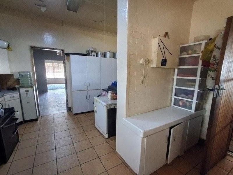 A functional kitchen area featuring built-in cabinetry and tiled flooring, offering potential for modernization and aesthetic updates.