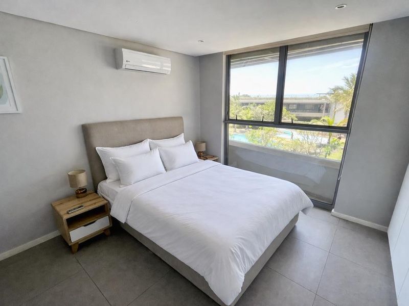 Modern bedroom featuring tiled flooring, an air conditioning unit, and a large window with views of the complex pool area.
