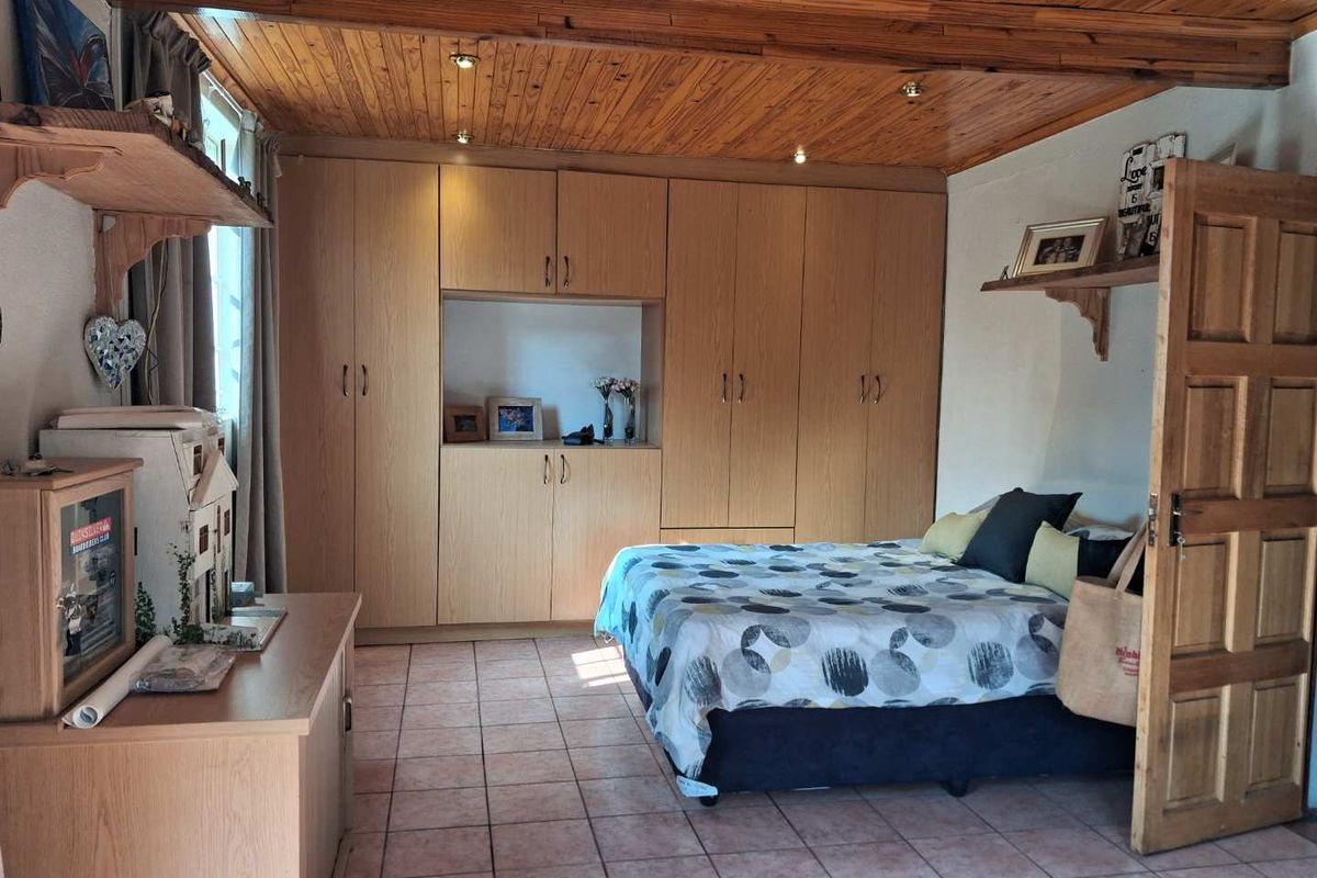 A bedroom featuring built-in wooden cabinetry, tiled flooring, and a timber-paneled ceiling with recessed lighting.