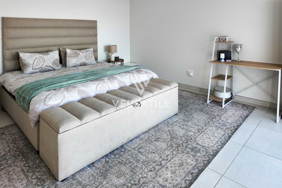 A well-maintained bedroom featuring neutral wall tones and clean tiled flooring, providing a bright and comfortable living space.