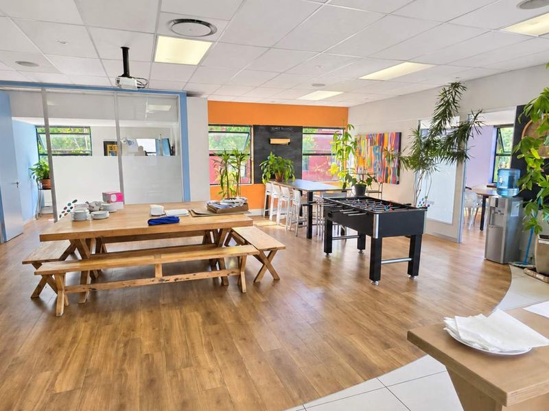Spacious open-plan office area featuring laminate flooring, suspended ceilings with recessed lighting, and glass partitions, providing a bright and functional workspace.