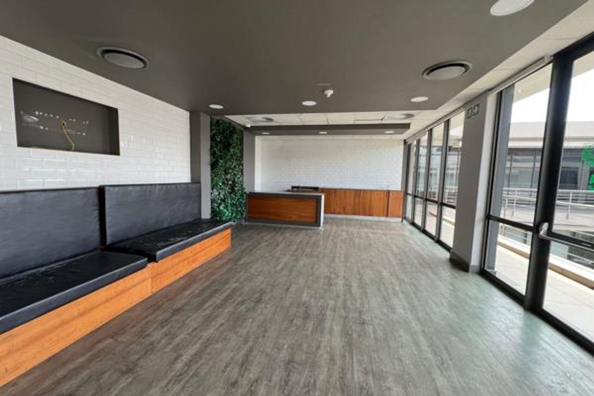 Modern office space featuring built-in bench seating, wooden cabinetry, subway tile accents, and large windows providing ample natural light.