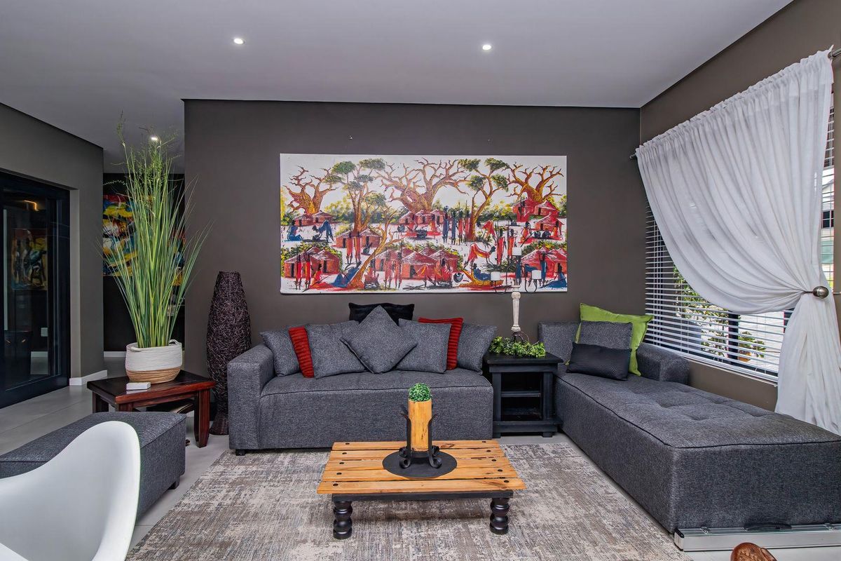 A modern living room featuring recessed ceiling lighting, tiled flooring, and large glass sliding doors leading to an outdoor area.