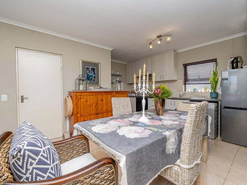 Open plan dining and kitchen area featuring tiled flooring, neutral cabinetry, and functional kitchen workspace.