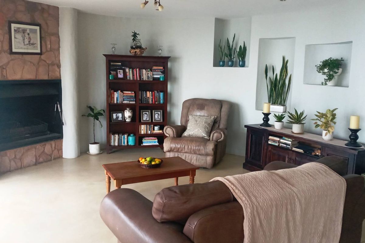 A comfortable living room featuring a stone-clad fireplace, built-in wall niches, and smooth flooring, creating a warm and inviting atmosphere.
