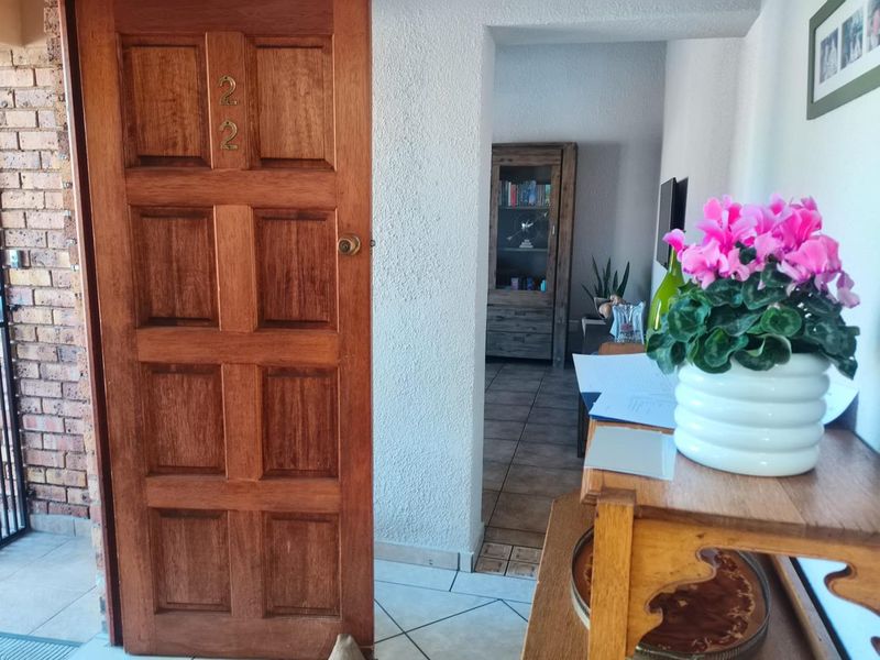 Entrance area featuring a solid wood panel door and tiled flooring, providing access into the main living space of the property.