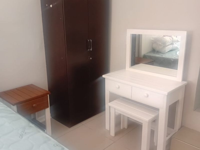 A bedroom featuring tiled flooring and neutral wall finishes, providing a functional space for rest.