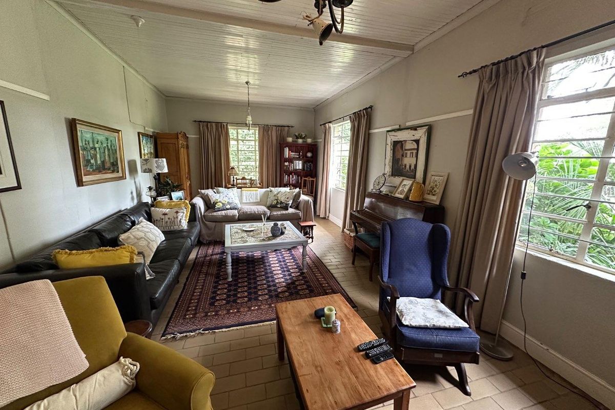 Spacious living room featuring traditional tiled flooring and a classic timber panelled ceiling, offering a comfortable and character-filled family space.