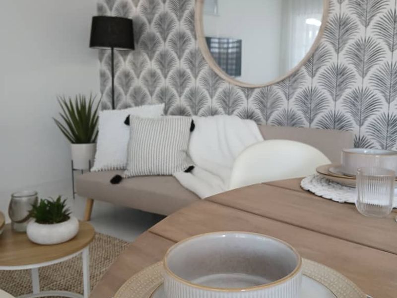 A well-presented living area featuring decorative patterned wallpaper and neutral finishes, creating a cozy and inviting atmosphere.