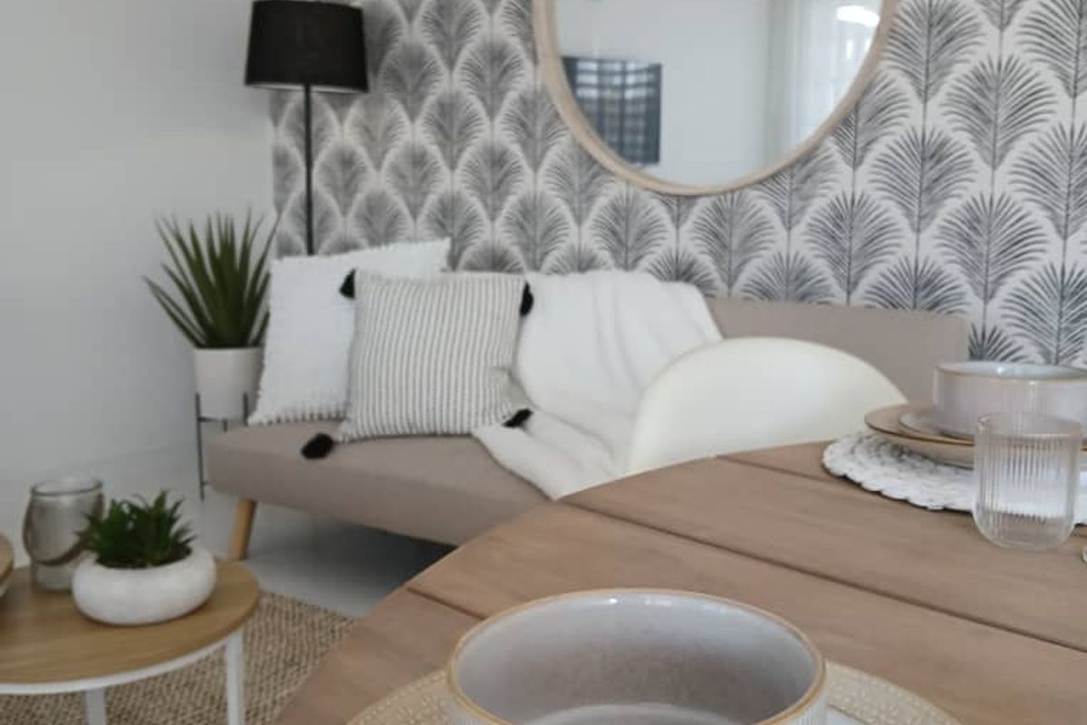 A well-presented living area featuring decorative patterned wallpaper and neutral finishes, creating a cozy and inviting atmosphere.