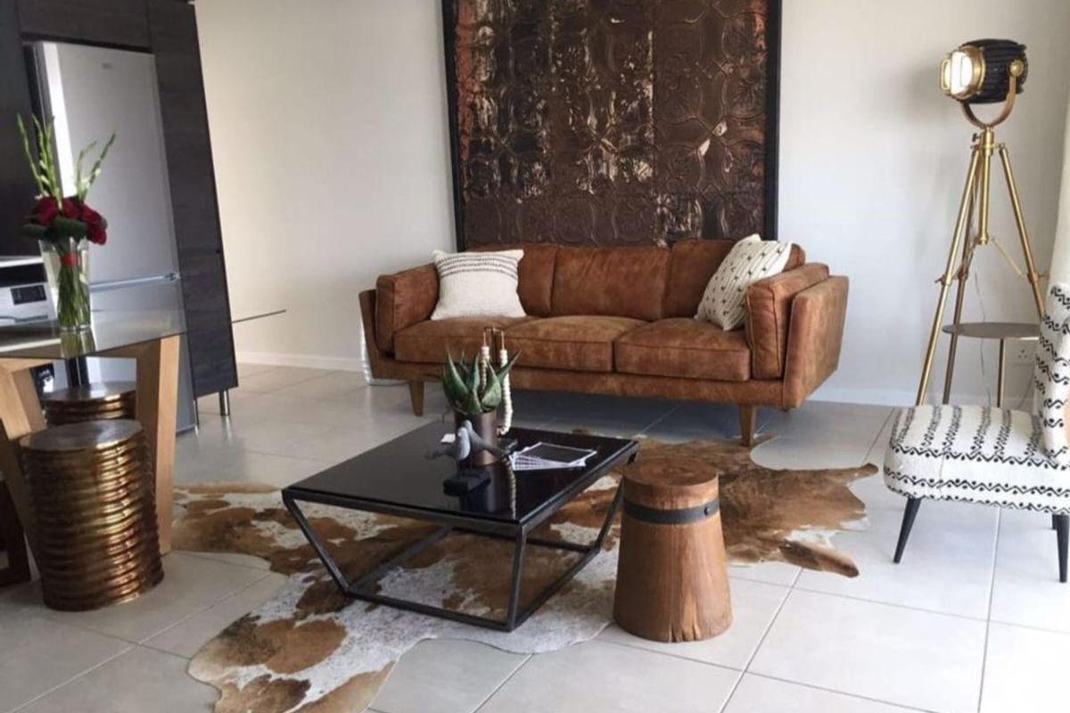 A well-maintained living area featuring neutral tiled flooring and integrated kitchen cabinetry, providing a clean and functional open-plan living space.