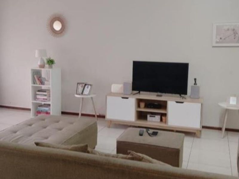 A living room area featuring neutral tiled flooring and plain walls, providing a blank canvas for interior design updates.